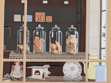 Set of enamel storage canisters with vintage labels on a kitchen counter.