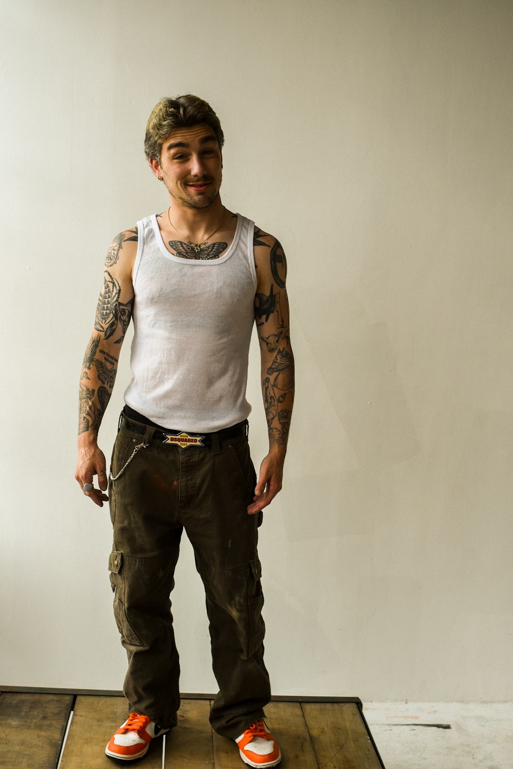 a man with tattoos standing on a wooden platform