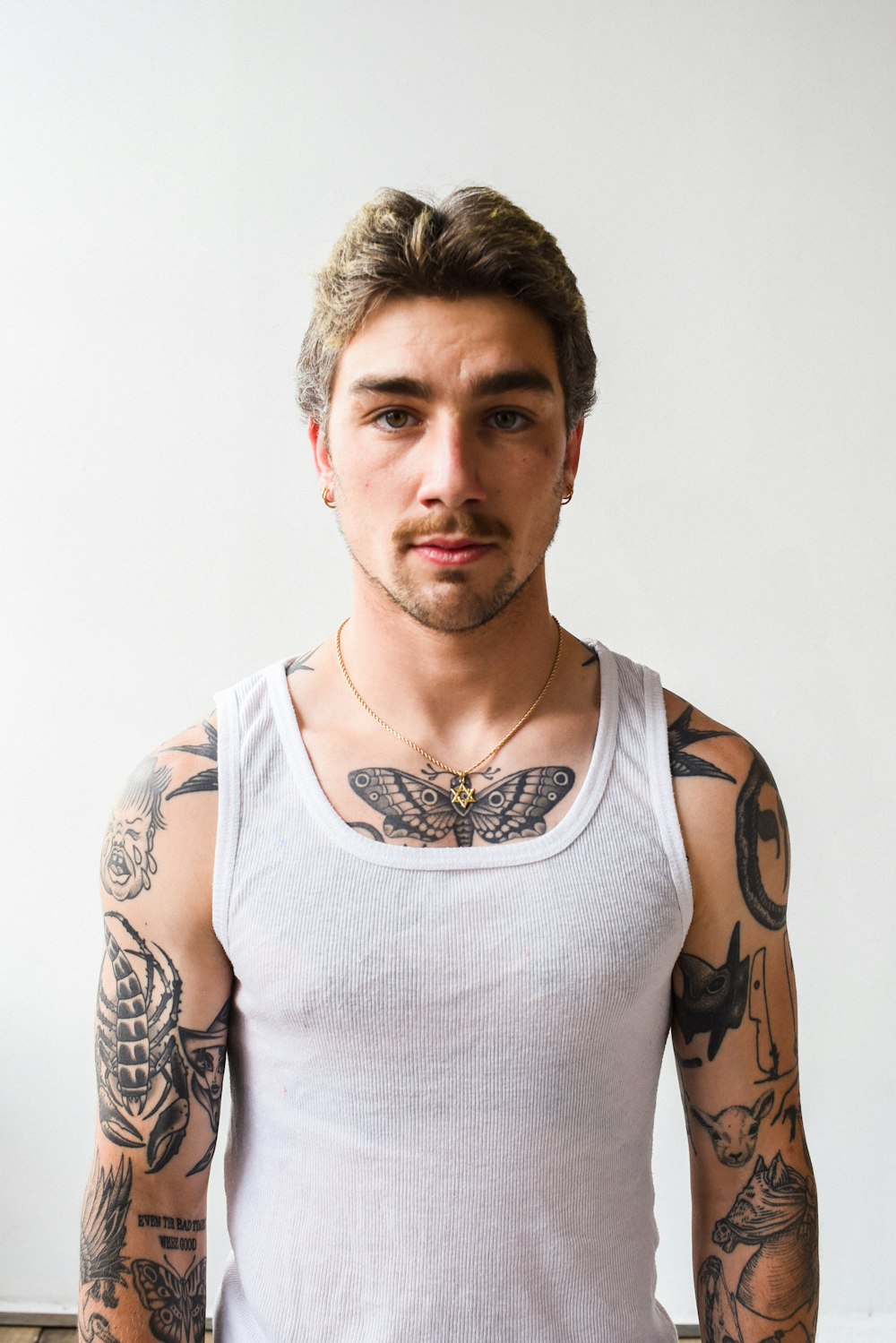 a man with tattoos on his arms and chest