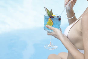a woman in a bikini holding a cocktail