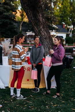 a group of people standing next to each other near a tree