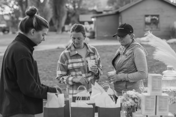 A warm group of friends happily exchanging forgotten items outdoors.
