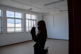 A friendly Parisian cleaning professional answering a phone call in a bright, modern apartment.