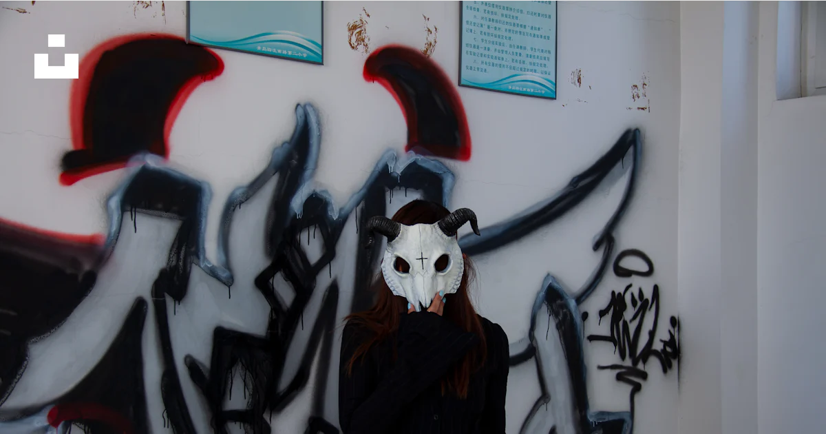 Alone Mask Image A woman wearing a mask standing in front of a wall covered in graffiti ...