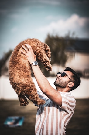A joyful dog and owner sharing a training moment in a sunny backyard.