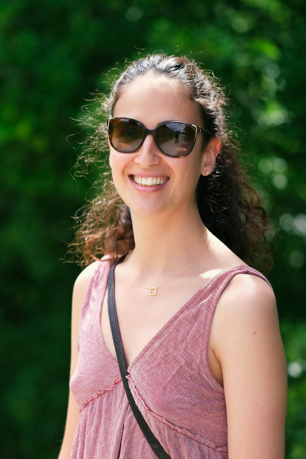 a woman wearing sunglasses and a pink dress