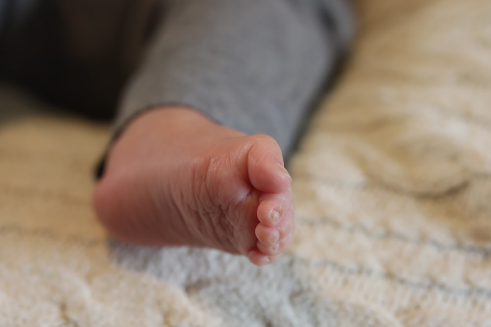 a close up of a baby's foot on a bed