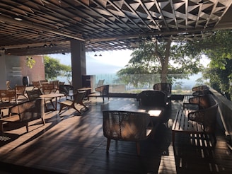 A spacious wooden terrace with comfortable seating and potted plants under soft lighting.