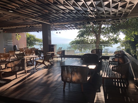 A spacious wooden terrace with comfortable seating and potted plants under soft lighting.