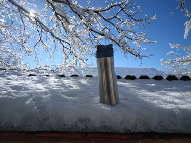 A sleek stainless steel thermos with a matte finish sitting on a wooden table with morning sunlight streaming in.