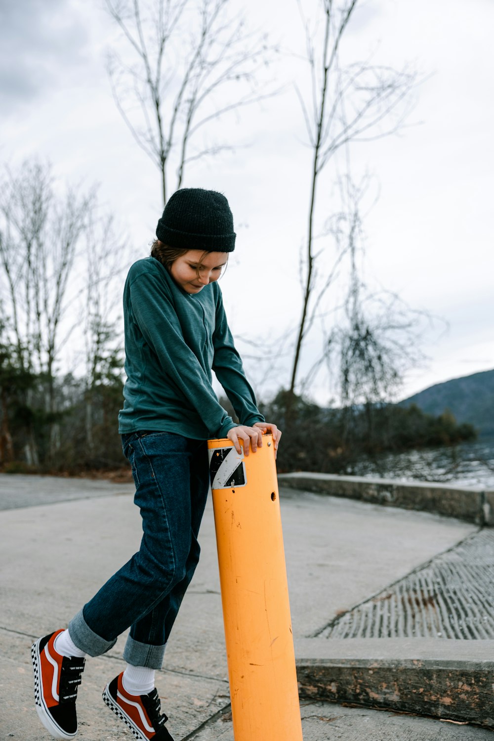 a young boy holding a skateboard on a sidewalk