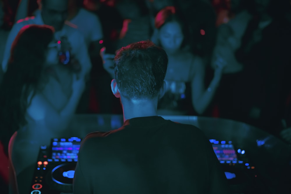 a dj playing music in front of a crowd of people