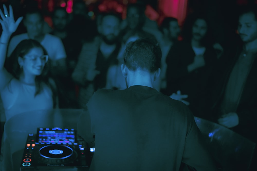 a dj mixing music in front of a crowd of people