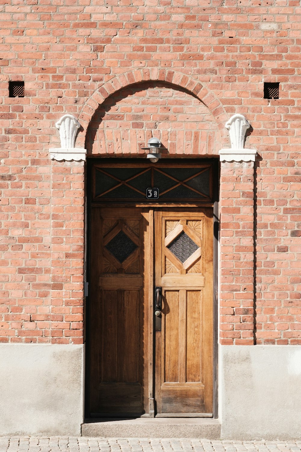 a brick building with a wooden door and arch