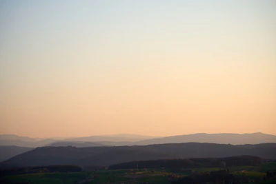 A serene landscape with gentle hills bathed in early morning light.