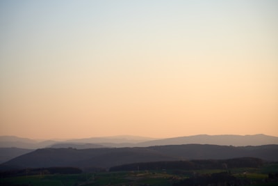 A serene landscape with rolling hills and a peaceful sunrise, symbolizing tranquility and reflection.