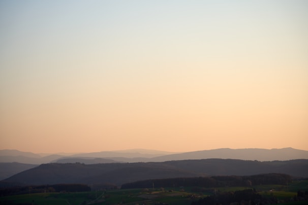 A serene landscape with gentle hills and a glowing sunrise, embodying hope and healing.