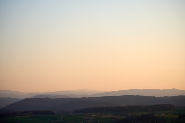 A soft, expansive landscape bathed in warm, early morning light, embodying calm and space.