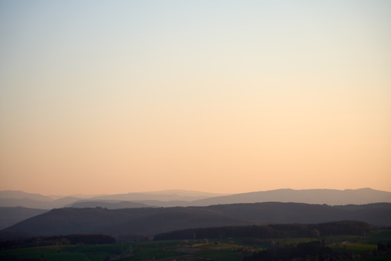 A serene natural landscape with a gentle sunrise over rolling hills, symbolizing balance and renewal.