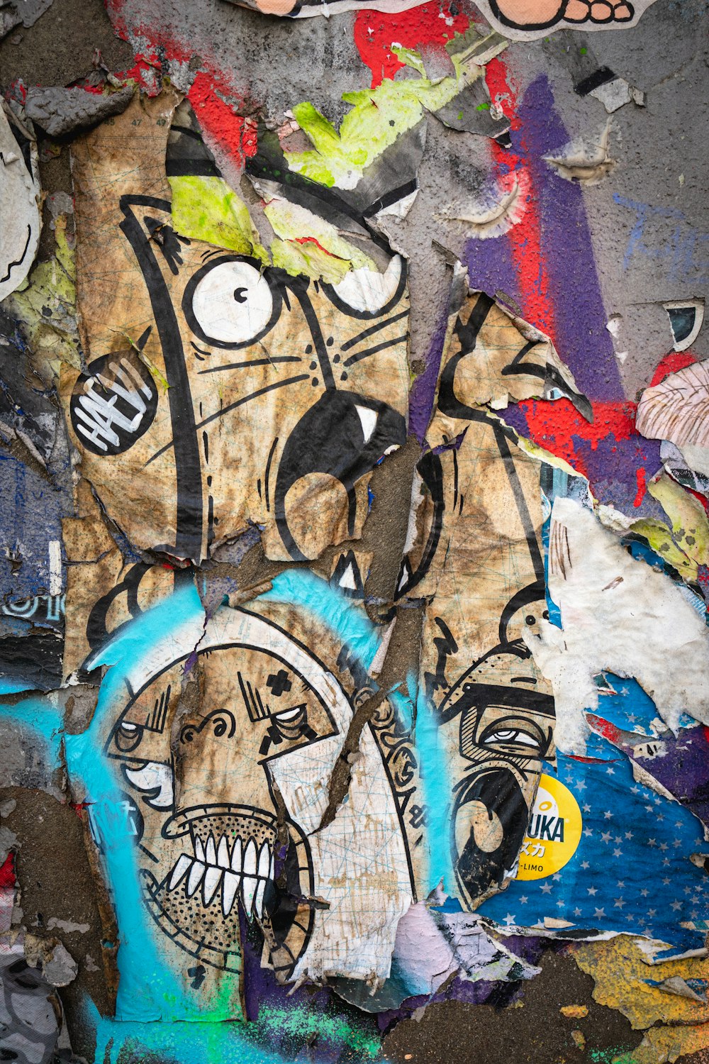 un muro coperto di molti graffiti e adesivi