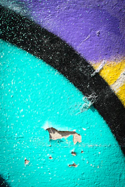 A close-up of a vibrant Banksy stencil on a weathered urban wall.
