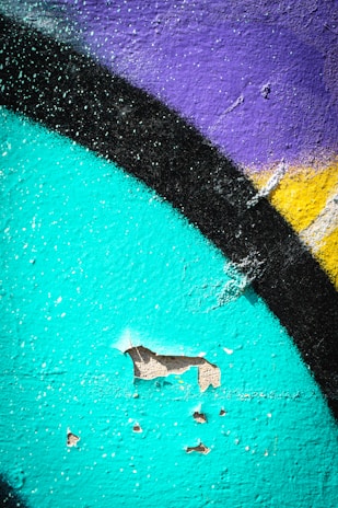 Close-up of paintbrush strokes on a vibrant building wall