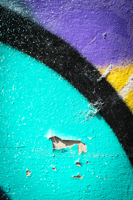 Close-up of colorful street art on a textured urban wall