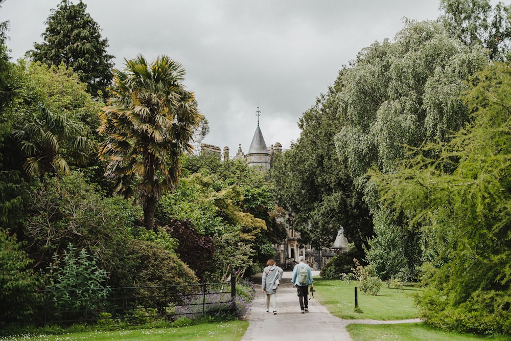 two people walking down a path in a park