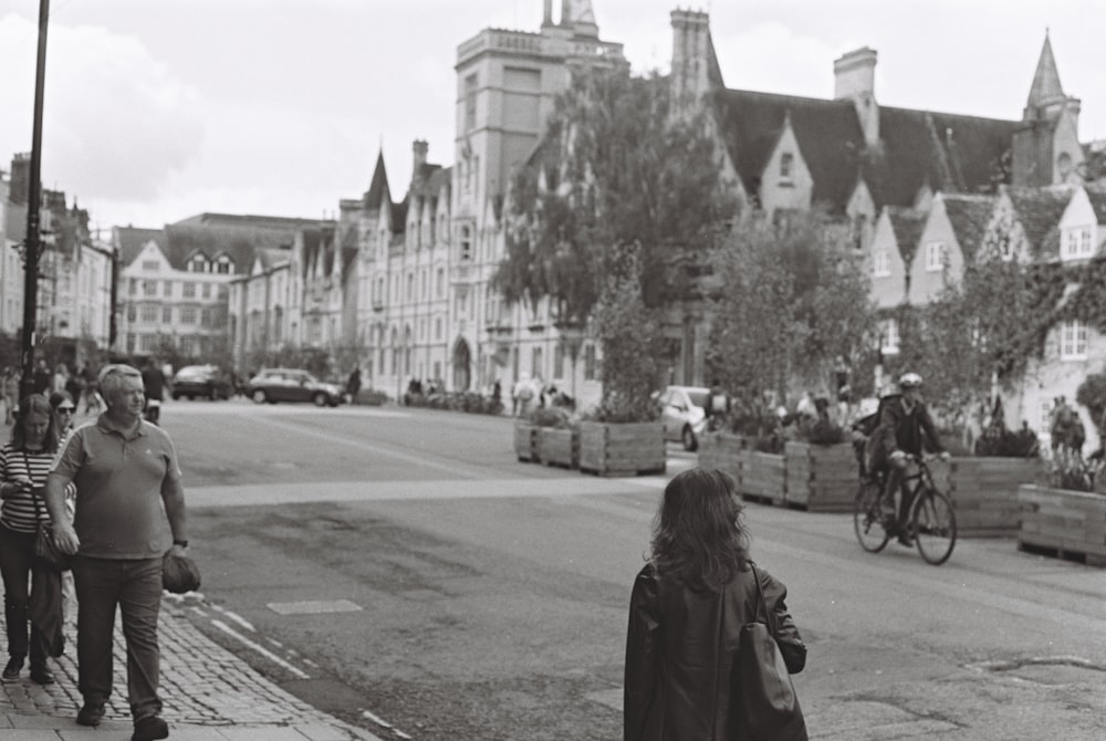 a black and white photo of people walking down the street