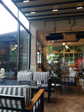 Interior view of a modern cafe with industrial design elements and warm lighting.