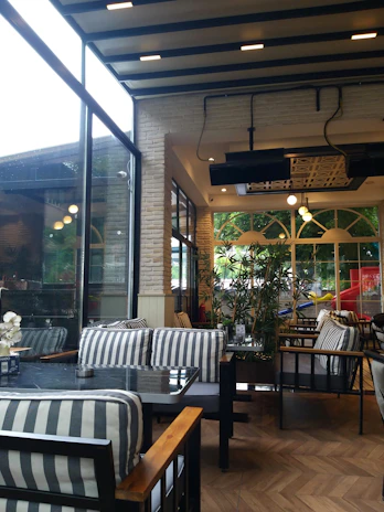 Interior view of a modern cafe with industrial design elements and warm lighting.