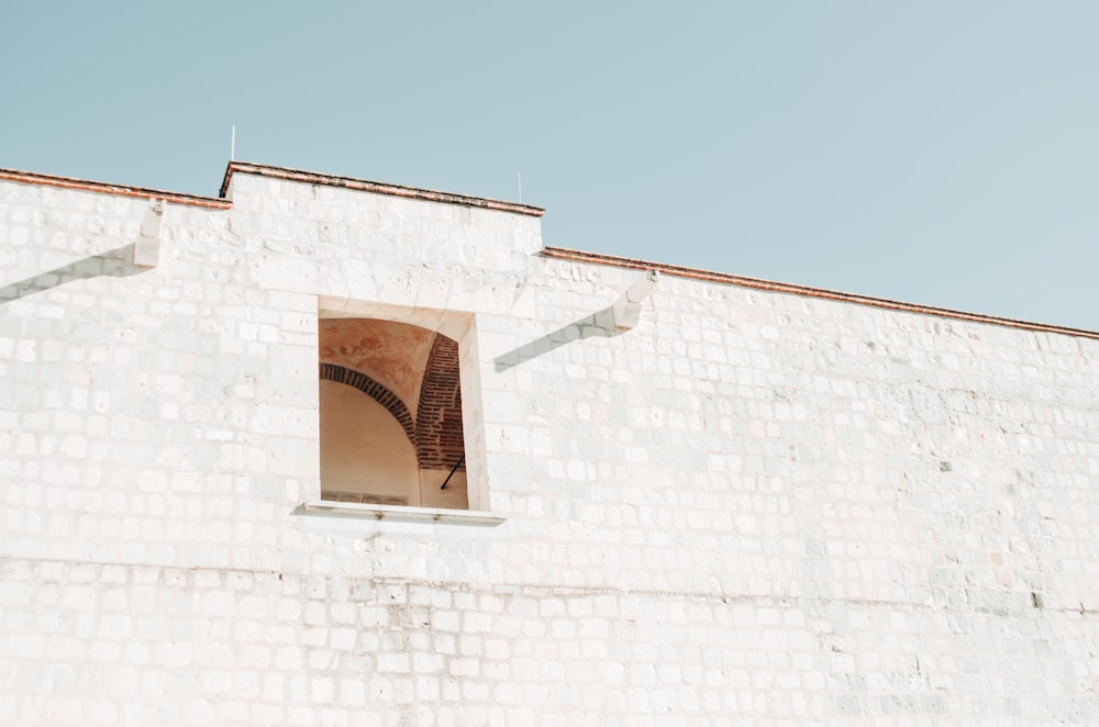 a white brick building with a window and a staircase