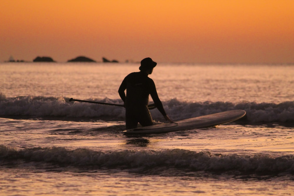 a man riding a surfboard on top of a body of water