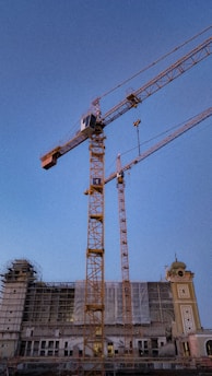 Workers building a commercial building exterior during daytime.