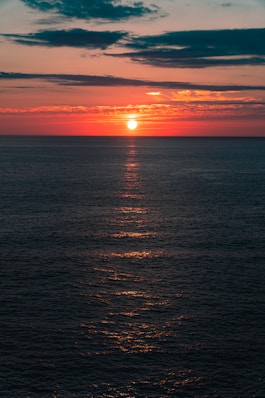 a large body of water with a sunset in the background