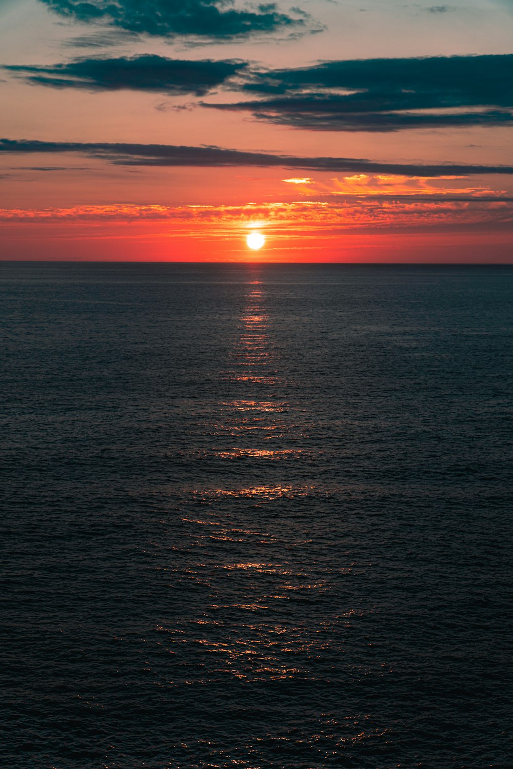 a large body of water with a sunset in the background