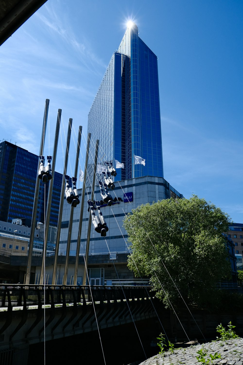 a tall building sitting next to a river under a blue sky