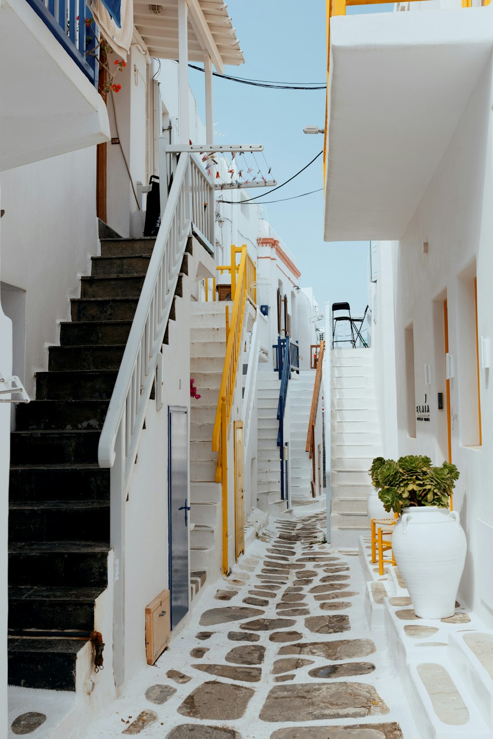 a narrow street with stairs and a potted plant