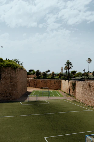 A completed synthetic grass sports field with children playing soccer.