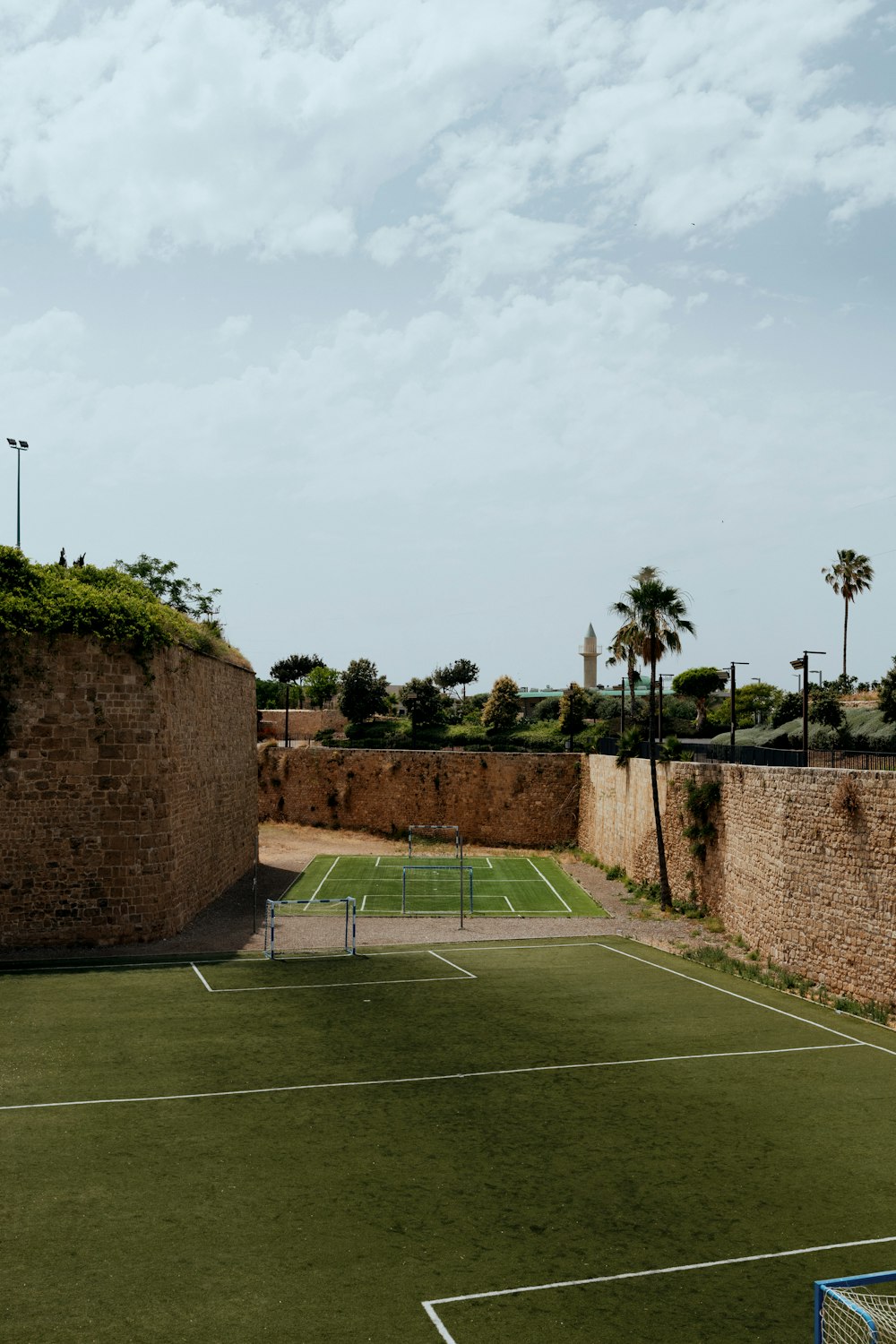 a tennis court surrounded by a stone wall