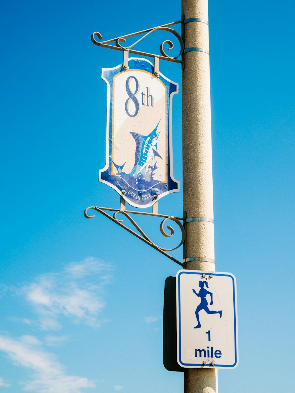 a blue and white sign hanging from a metal pole