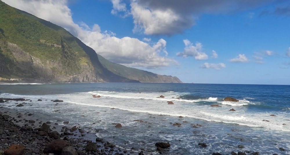 a rocky beach with a mountain in the background