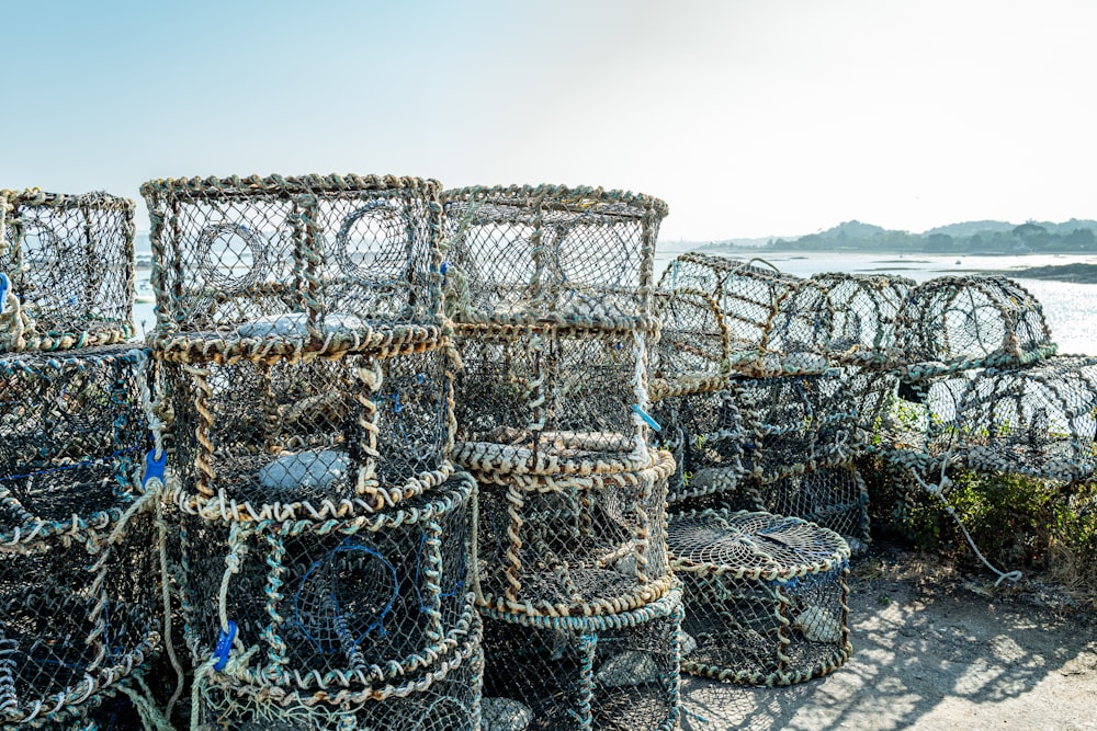 a pile of lobster cages sitting on top of a beach