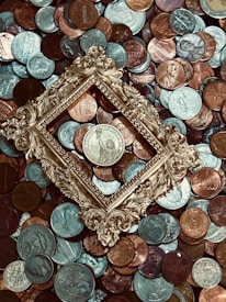An artistic arrangement of vintage coins and silver pieces on a textured surface.