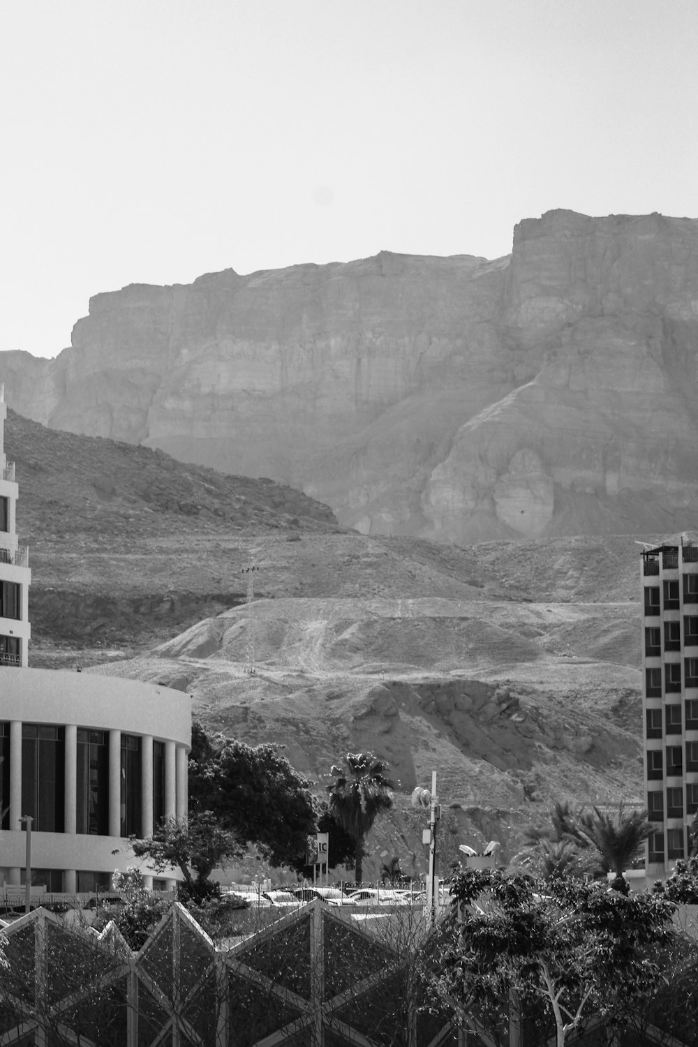 a black and white photo of a building in front of a mountain