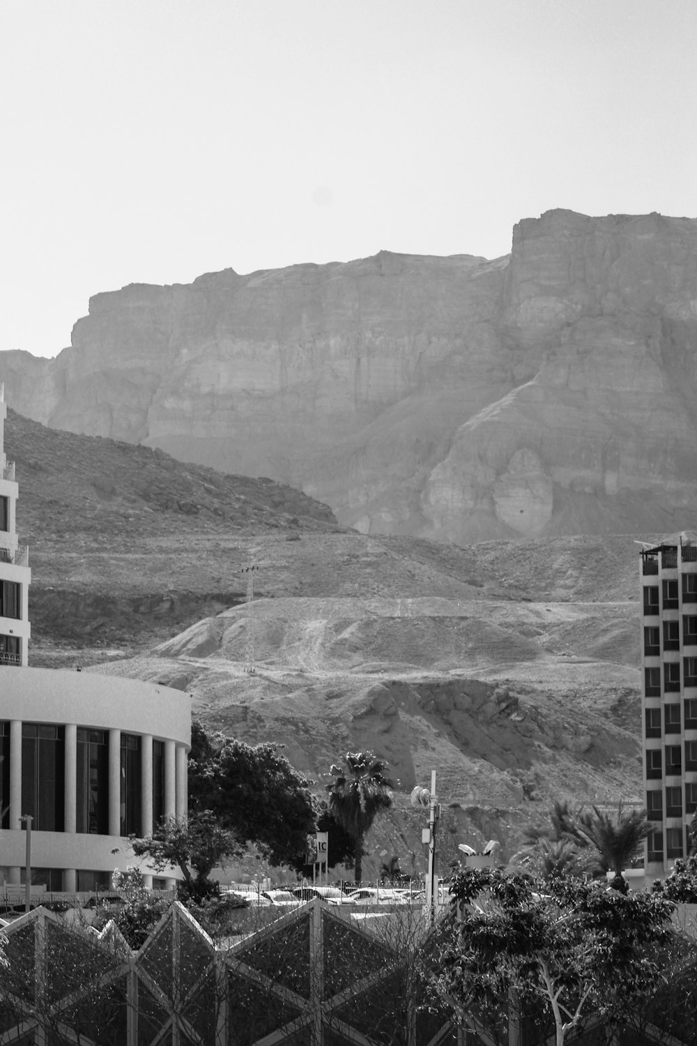 Una foto in bianco e nero di un edificio di fronte a una montagna