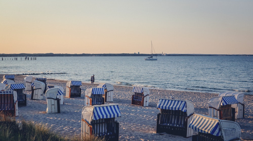 eine Gruppe von Liegestühlen, die auf einem Sandstrand sitzen