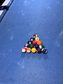 An overhead view of billiard balls arranged in a challenging pattern for practice.