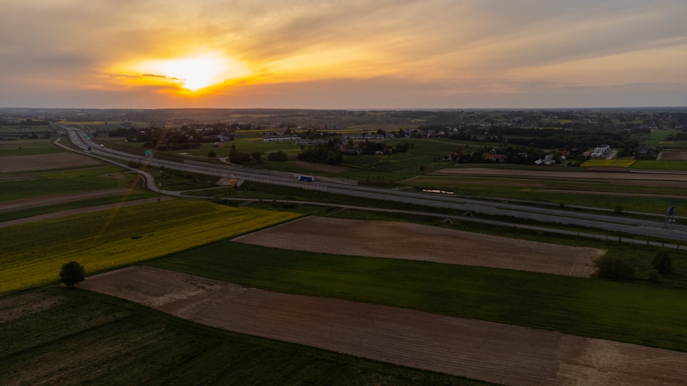 the sun is setting over a rural area