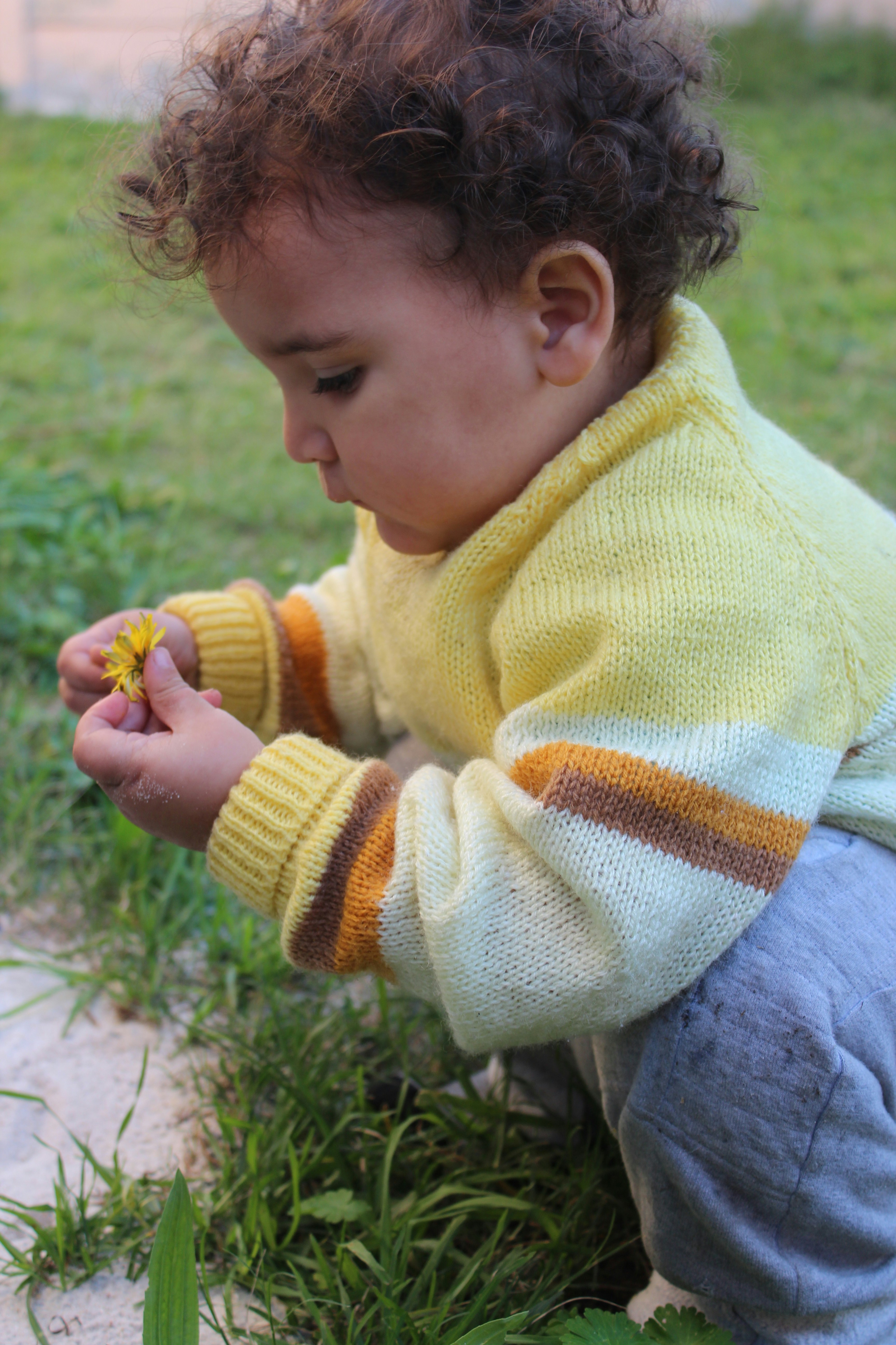 Un niño pequeño está jugando con una flor